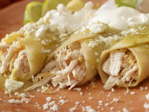 Tres burritos de pollo con salsa en un plato marrón Tres burritos de pollo con salsa en un plato marrón