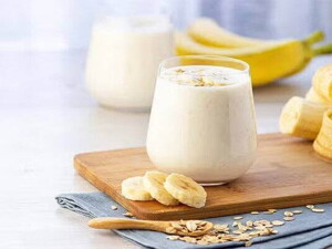 Un vaso con batido de plátano y plátanos alrededor Un vaso con batido de plátano y plátanos alrededor