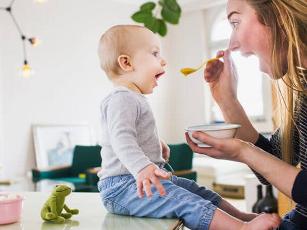 Conoce por qué son tan importantes los probióticos saludables en los niños Mamá alimentando a su hijo con una papilla