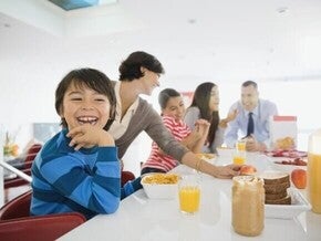 Familia el desayuno juntos en la cocina, sentados alrededor de la mesa.