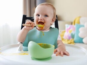 Bebé practicando el agarre de pinza durante la alimentación.