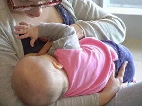 Madre dando de amamantar a su bebé, produciendo leche materna