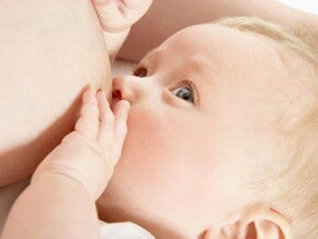 Bebé tomando leche, amamantando.