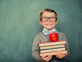 Niño sonriendo con libros en la mano.