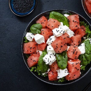 Ensalada de Sandía, Espinacas y Queso Un bowl que contiene cubos de sandía, espinacas y queso