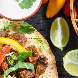 Fajitas rellenas con res y una salsa con limones a un lado