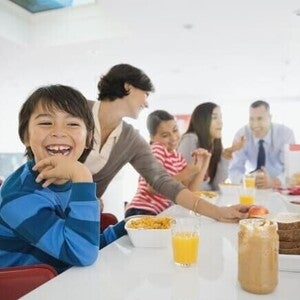 Familia el desayuno juntos en la cocina, sentados alrededor de la mesa.