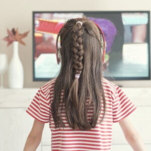 Niña pequeña viendo la televisión.