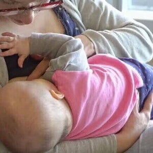 Madre dando de amamantar a su bebé, produciendo leche materna