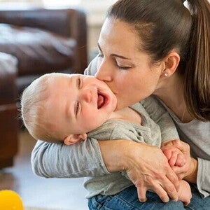 Madre dando beso en la mejilla al bebe