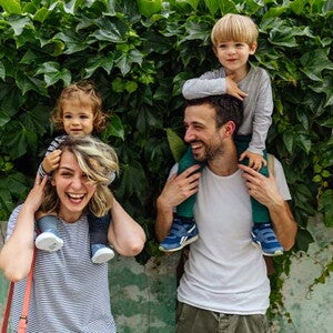 Los padres riendo con los hijos en brazos