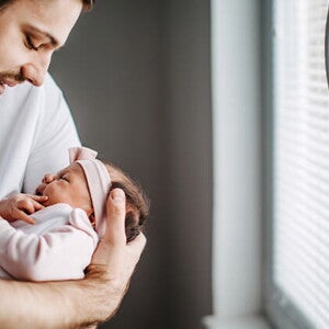 Los granitos en la cara de los bebés es un fenómeno común Papá alzando su bebé y revisando los granito de su cara