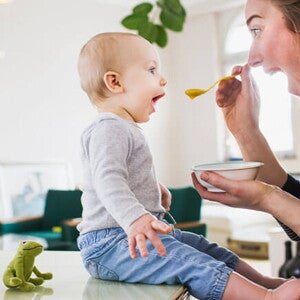 Conoce por qué son tan importantes los probióticos saludables en los niños Mamá alimentando a su hijo con una papilla