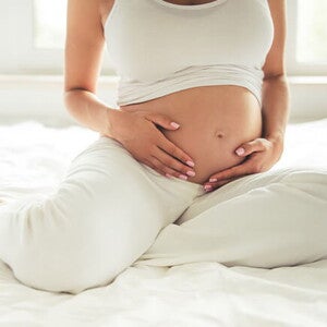 Conoce qué es el líquido amniótico y su función. Mamá tocando el vientre.