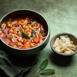 Un plato que contiene sopa de vegetales con pasta de fideo