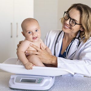 Doctora pesando al bebé.