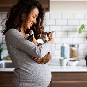 Mujer embarazada sosteniendo su gatito Mujer embarazada sosteniendo su gatito