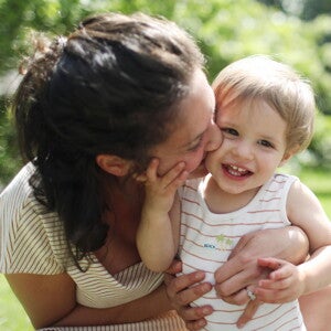 Mamá y niño pequeño sonriendo al aire libre en primavera.