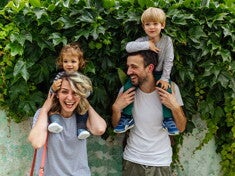 Estilos de crianza para educar a mi hijo Los padres riendo con los hijos en brazos