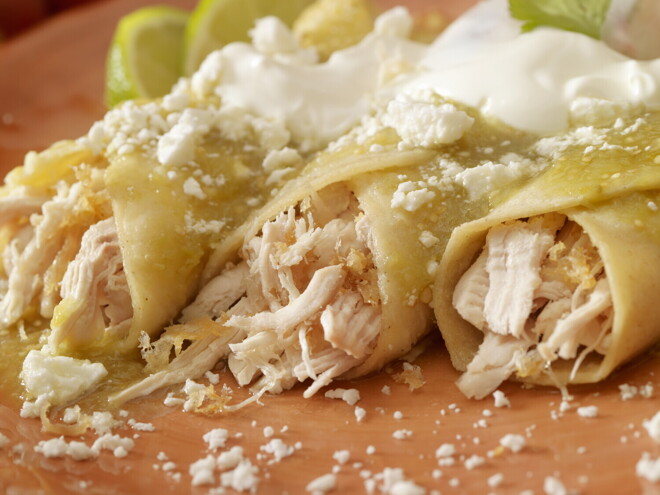 Tres burritos de pollo con salsa en un plato marrón Tres burritos de pollo con salsa en un plato marrón