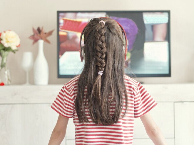 Niña pequeña viendo la televisión.