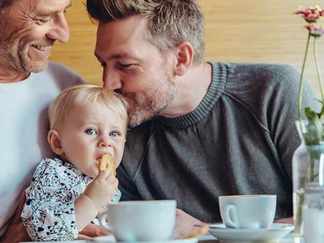 Conoce cuándo puedes darle galletas para bebés a tu hijo Niña comiendo galletas para bebés con su papá y abuelo