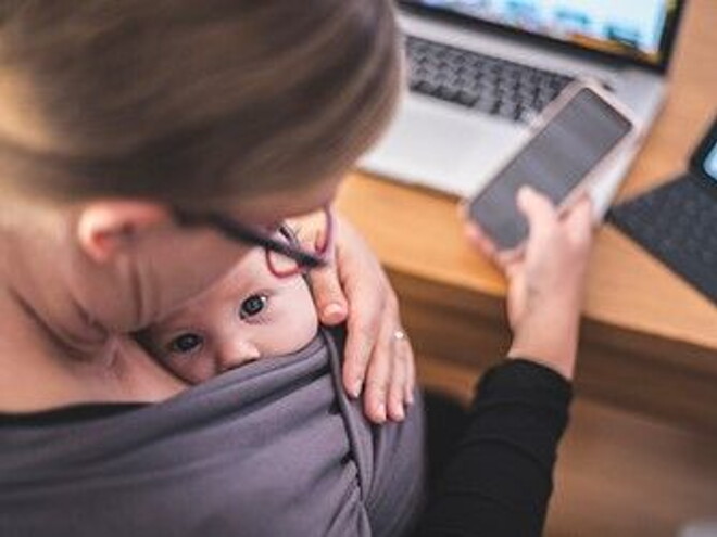 Como lidiar con la culpa parental madre trabajando con su hijo en brazos
