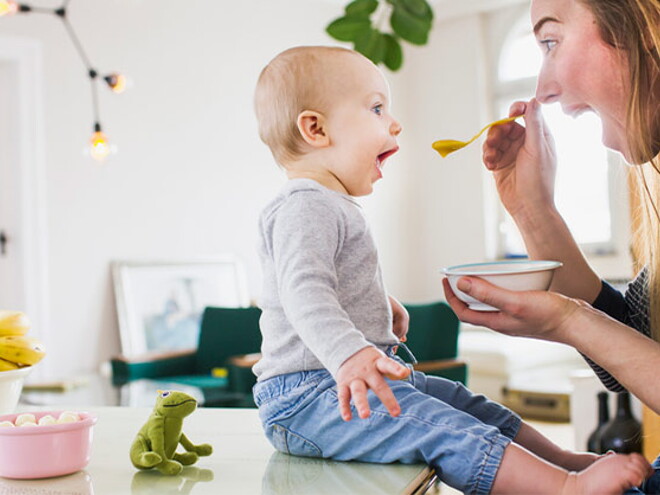 Conoce el desarrollo de tu bebé de 10 meses. Bebé de 10 meses sentado comiendo con mamá