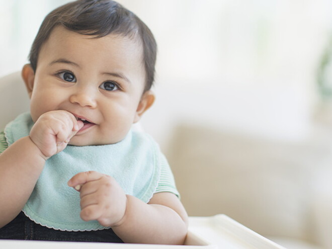 Conoce el desarrollo de tu bebé de 9 meses Bebé de 9 meses sentado sonriendo