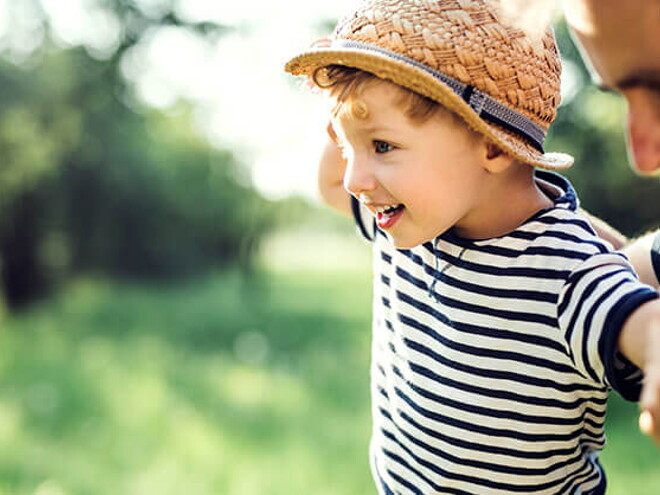 Conoce qué es la motricidad gruesa y cuáles son sus beneficios. Niño haciendo equilibrio con su padre.