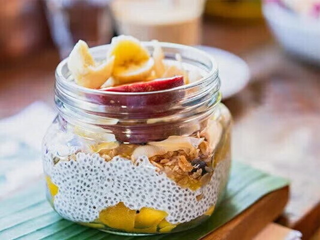 Un frasco que contiene pudín de chía y frutas Un frasco que contiene pudín de chía y frutas