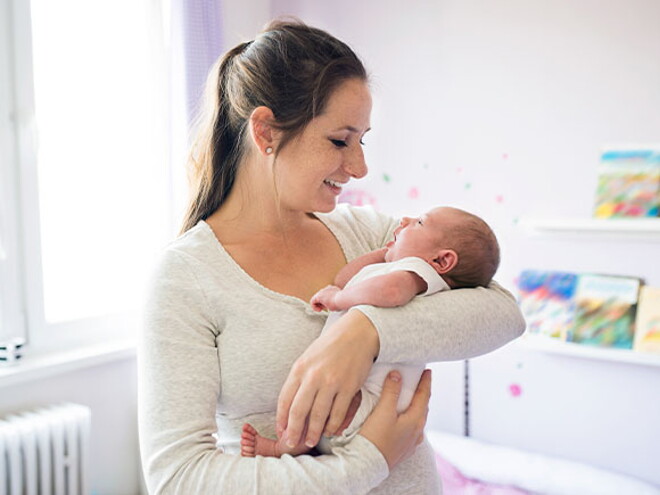 Conoce todo lo que debes saber si eres mamá primeriza. Mamá primeriza alzando en brazos a su bebé recién nacido.