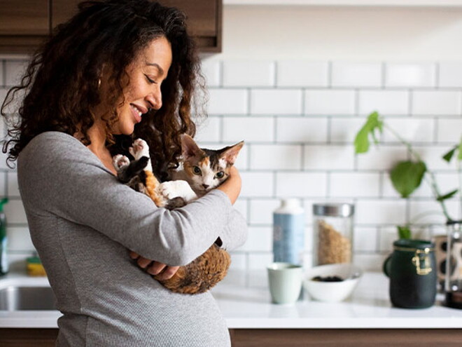 Mujer embarazada sosteniendo su gatito Mujer embarazada sosteniendo su gatito
