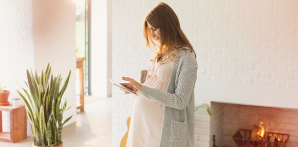 Sigue algunos consejos para enfrentar los cambios en los senos Mujer embarazada mirando un dispositivo