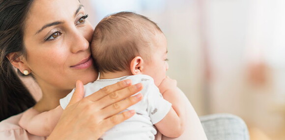 Conoce el desarrollo de un bebé de tres meses. Mamá alzando a su bebé de tres meses.
