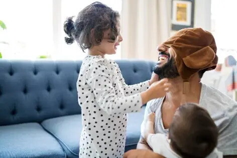 Las actividades para trabajar las emociones son fundamentales niños jugando con su papá a expresar sus emociones