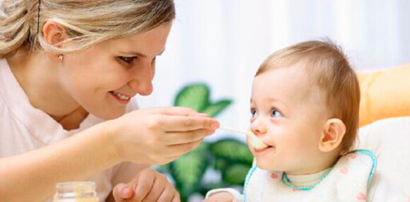 La alimentación es importante para un bebé de 6 meses Un bebé de 6 meses siendo alimentado por su madre