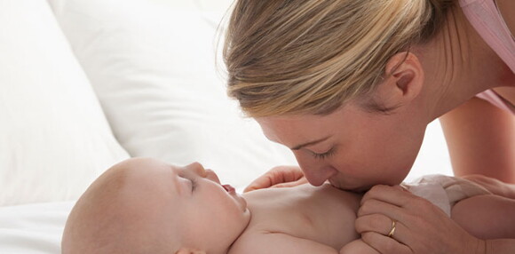 El desarrollo visual y auditivo son lo más importantes en un bebé de dos meses. Mamá jugando con su bebé de dos meses.
