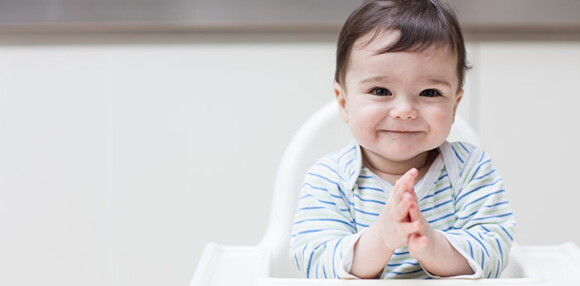 Conoce el desarrollo emocional de tu bebé de 10 meses. Bebé de 10 meses sentado sonriendo