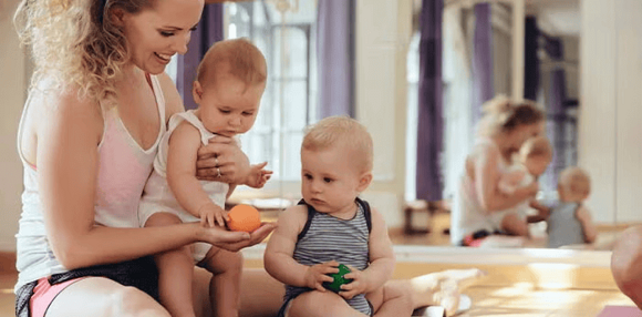 Mamá jugando con sus bebés mellizos.