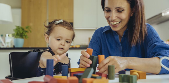Conoce los hitos de desarrollo de los bebés de 9 meses Mamá jugando con el bebé de 9 meses con los bloques.