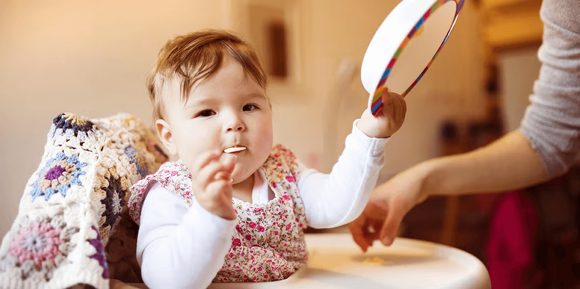 Un niño a la hora de comer con su plato en la mano Un niño a la hora de comer con su plato en la mano
