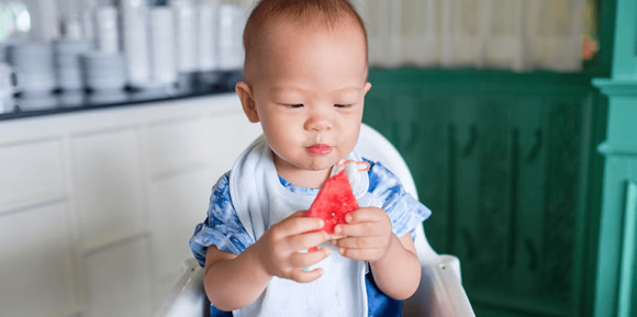 Niño sosteniendo un pedazo de sandía Niño sosteniendo un pedazo de sandía