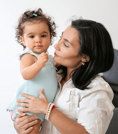 Una madre sosteniendo en brazos a su hija y sonriendo Una madre sosteniendo en brazos a su hija y sonriendo