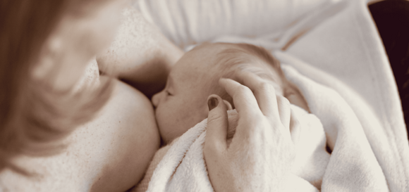 Una madre dando leche materna a su bebé Una madre dando leche materna a su bebé