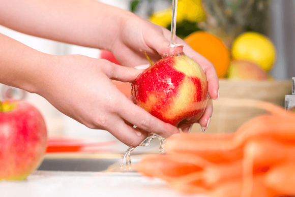 Mujer lavando una manzana Mujer lavando una manzana