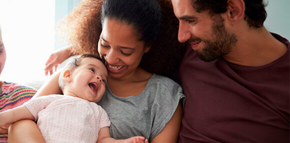 Los juegos son importantes en el desarrollo de tu bebé de 12 meses. Bebé de 12 meses jugando y sonriendo con sus padres.