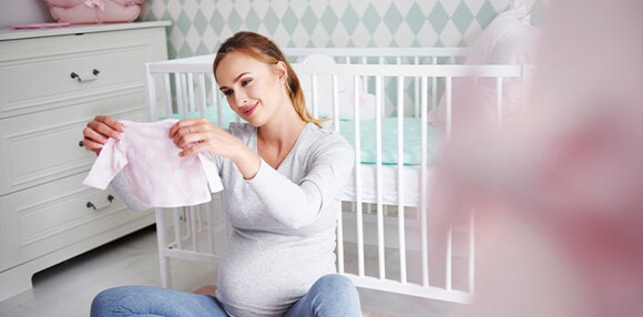 Se llama bebé arcoíris al que llega luego de una pérdida anterior. Mamá mirando la ropa de su bebé arcoíris.