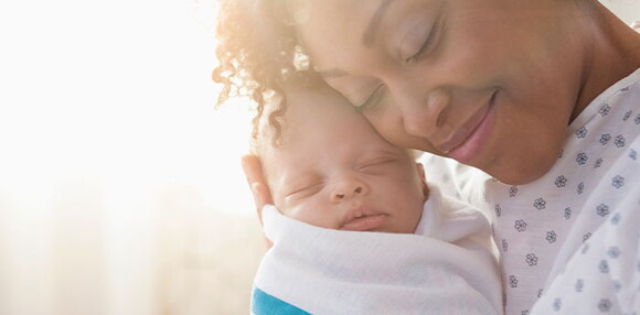 Identifica los signos de alarma de un bebé de dos meses. : Mamá abrazando a su bebé de dos meses.